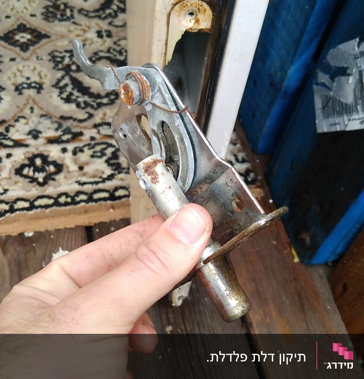 יד מחזיקה מנגנון מנעול חלוד בדלת עץ